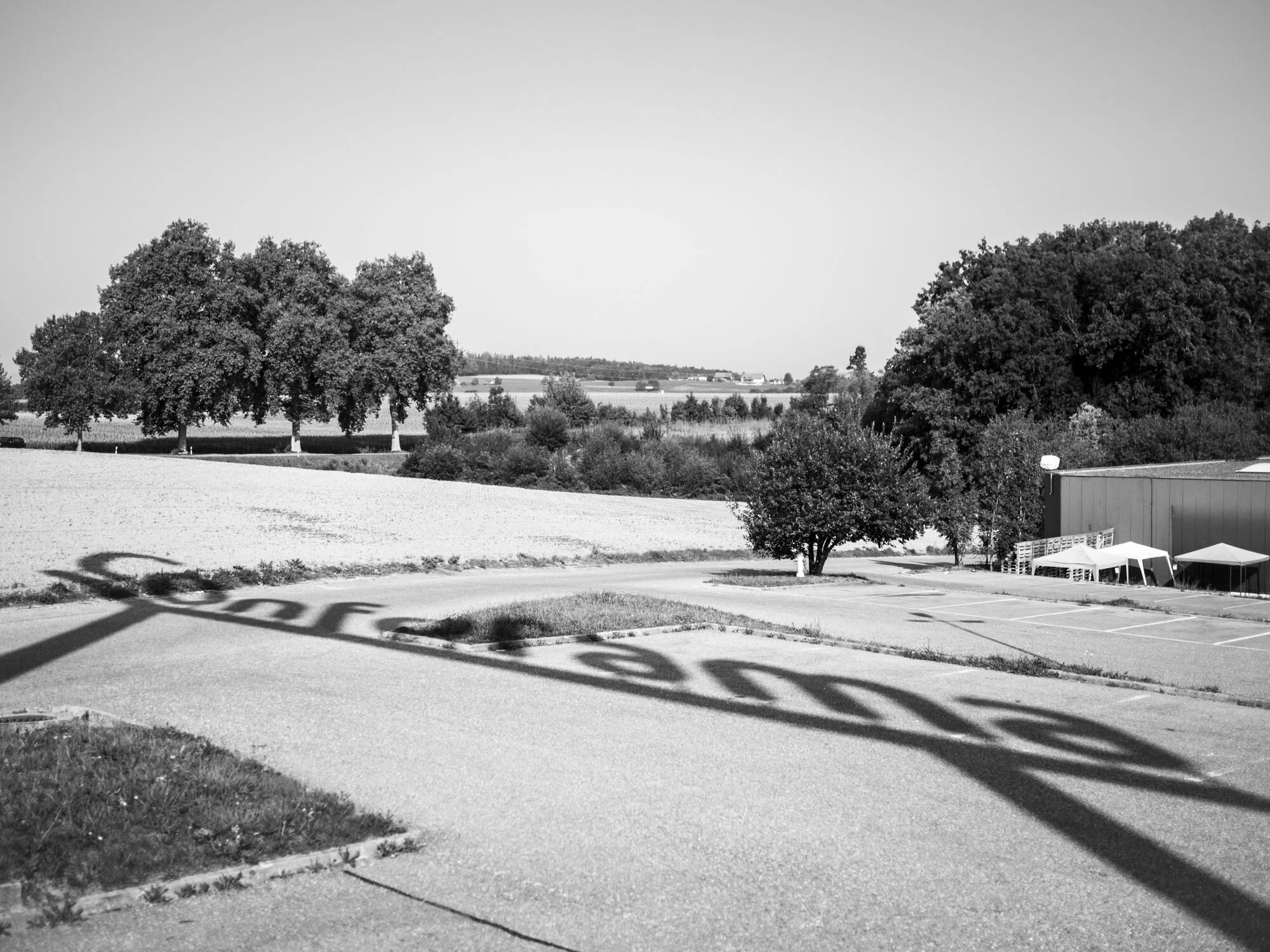 Ombre portée du portique Conforama sur fond de campagne à Granges-Paccot près Fribourg