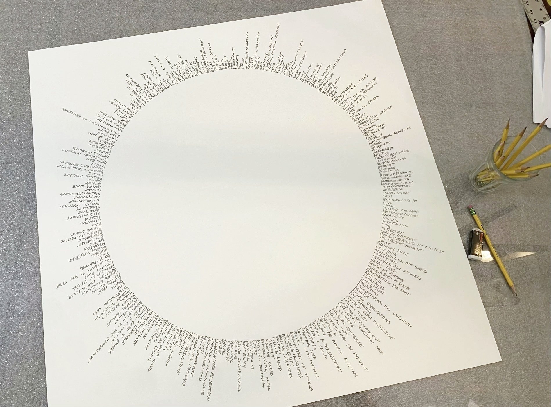 Taken Together , 2026. Pencil on paper. 32 × 32 inches. Taken Together considers the many things we share that make us human. Words and phrases describing the body, emotion, memory, need, and everyday experience occupy the same visual field. The