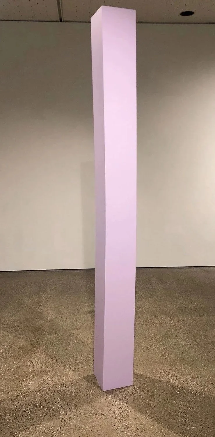 Lodestone , 2025. Enamel on shaped wood. 96 x 9 x 9 inches. The column appears straight and structurally sound from certain viewpoints, yet visibly bent and compressed from others, suggesting that what appears secure or dependable may be less cer