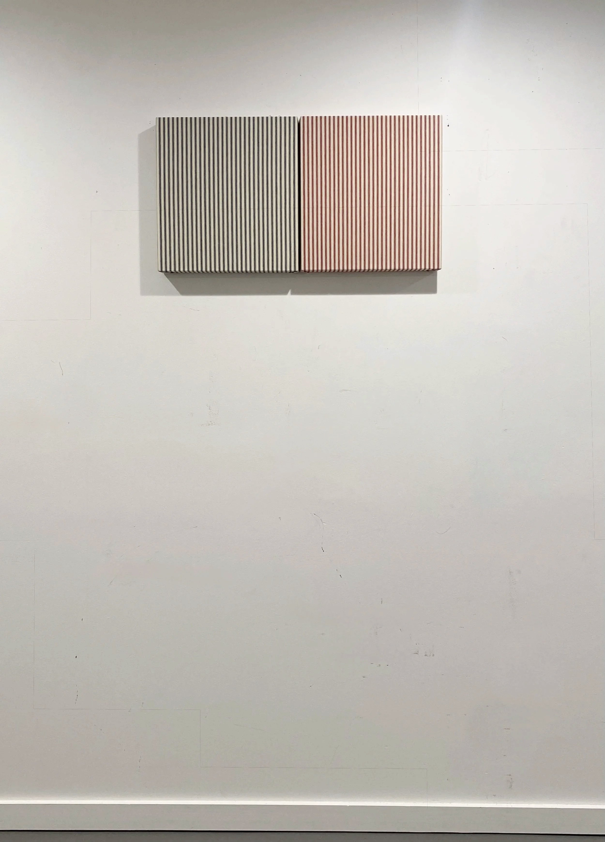  Sentimental X’s , 2026. Mattress ticking on uniquely shaped wood panel; two elements: 11 × 12.25 inches each, 1 1 × 23 inches overall. 