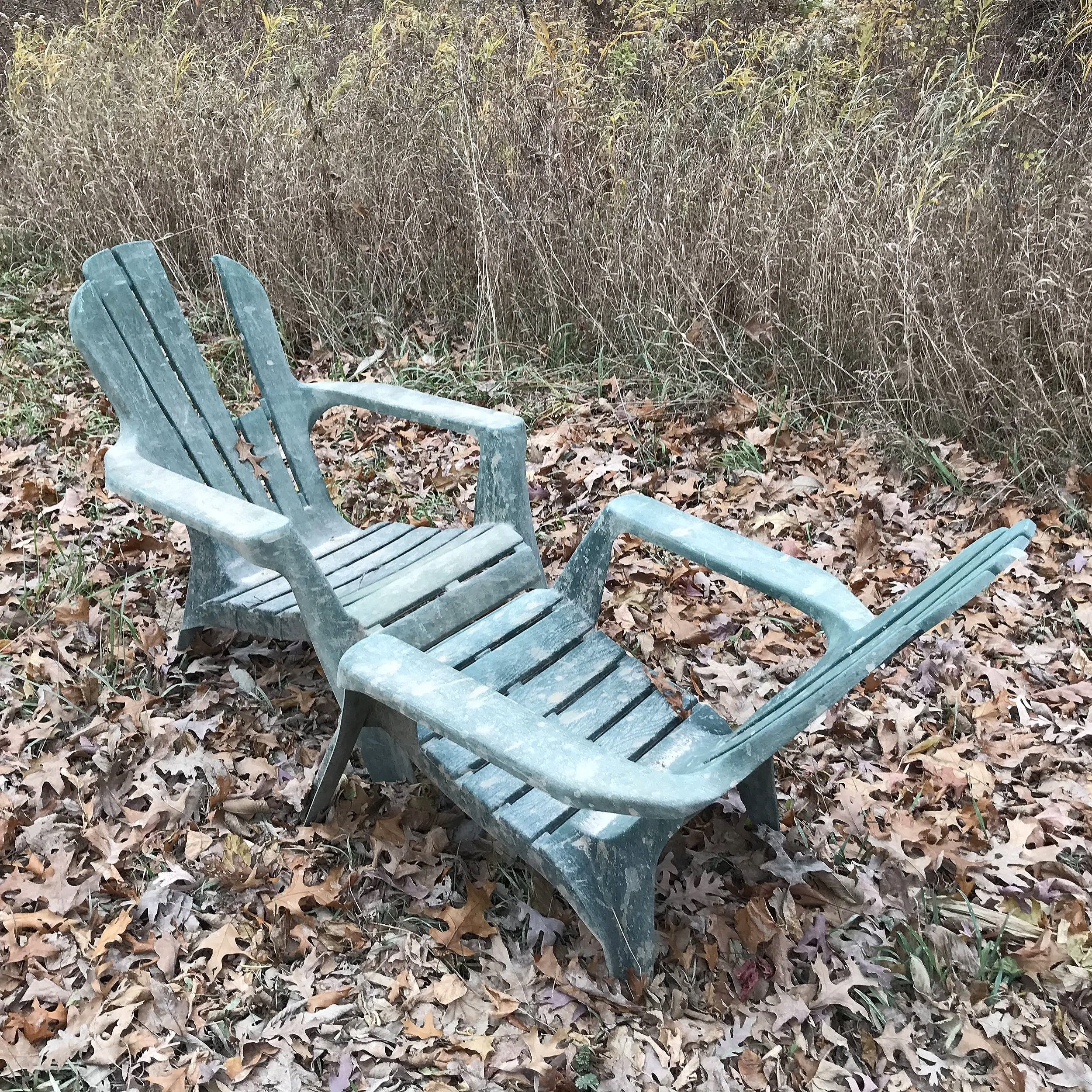   Adirondack Rack , 2026. Plastic Adirondack chairs. Huron-Manistee national Forestland, MI.  Two plastic Adirondack chairs, typically associated with domestic leisure spaces such as patios and backyards, were found in a clearing in the woods, presum
