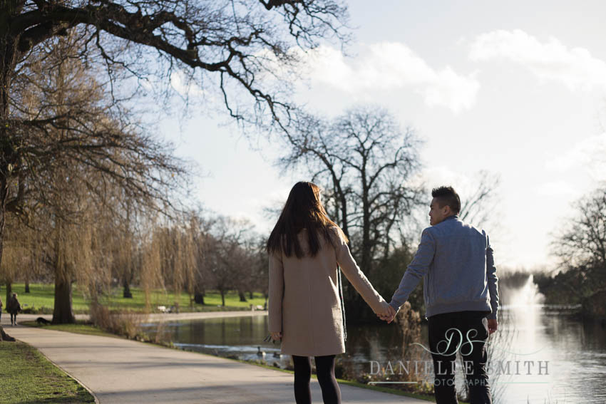 couple walking around lake in park