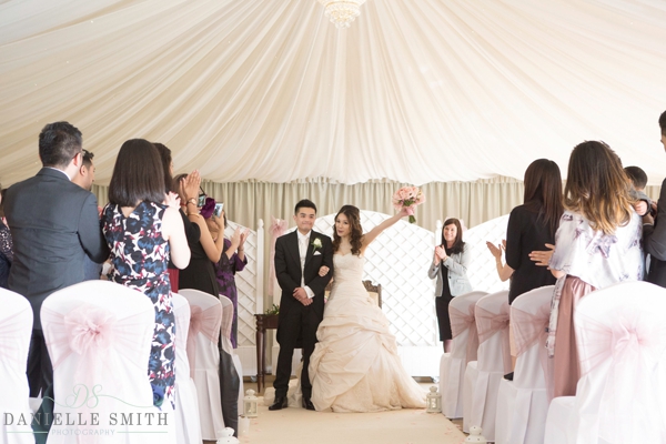 bride cheering as they walk down aisle