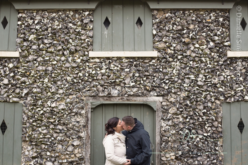 couple kissing in front of stone house