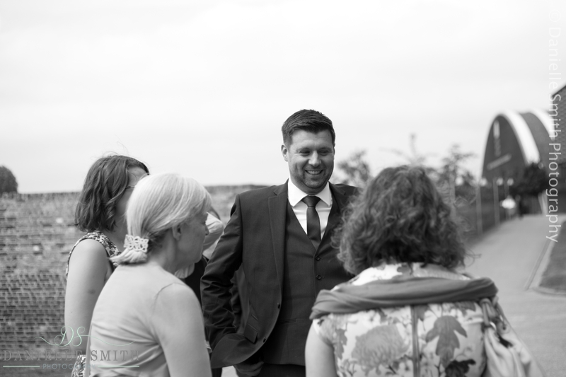 groom greeting wedding guests at barn wedding