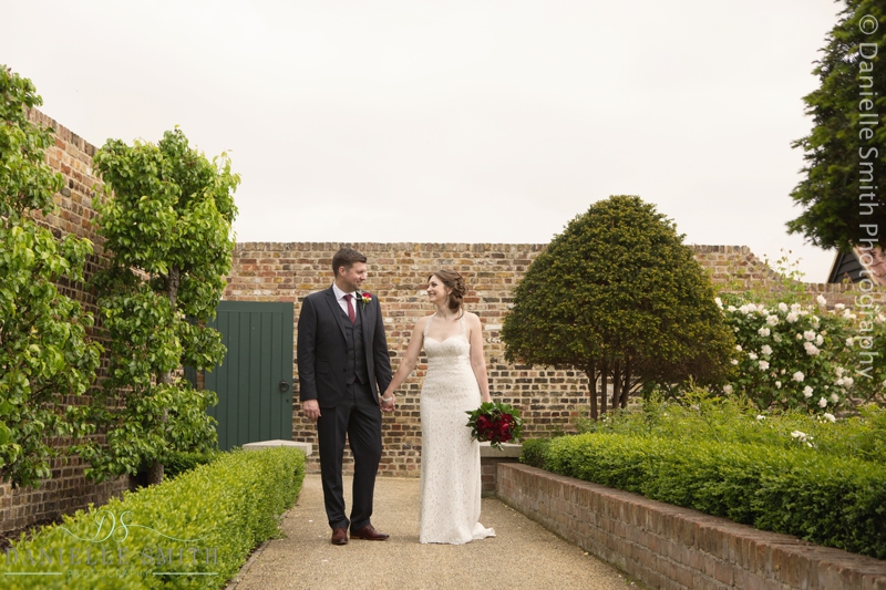 bride and groom walking in walled gardens