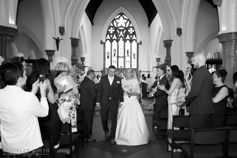 bride and groom walking down church aisle