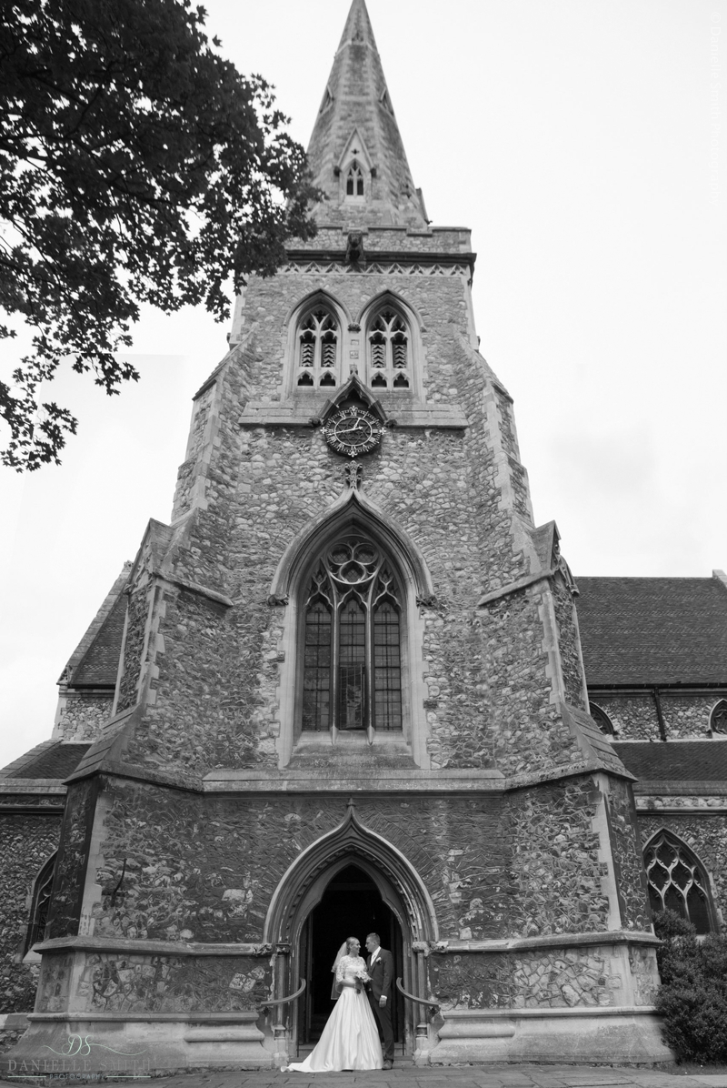 bride and groom outside church tower in Romford