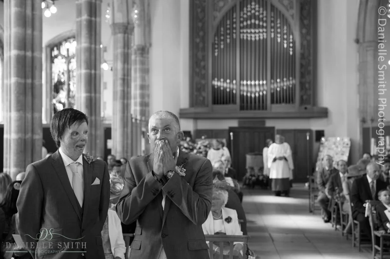 groom with hands on mouth waiting for bride