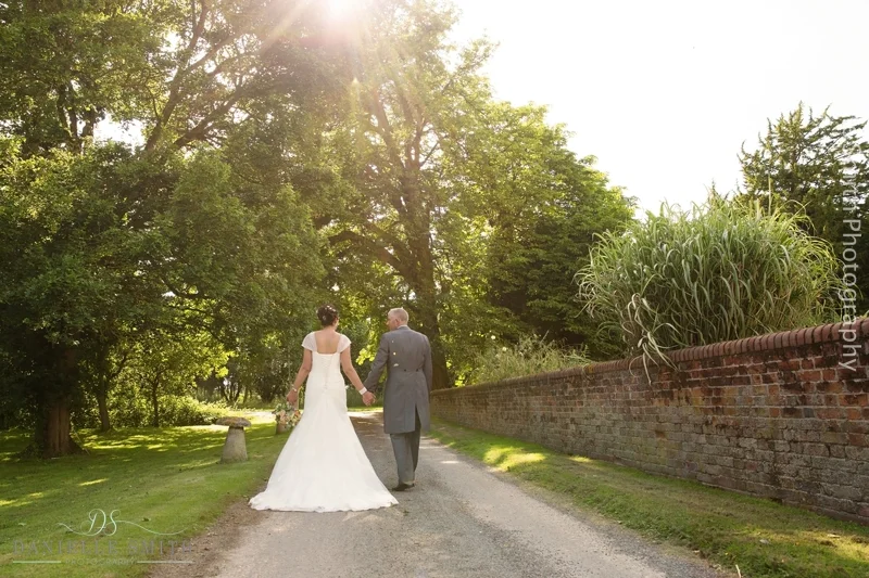 bride and groom walking down drive at houchins wedding