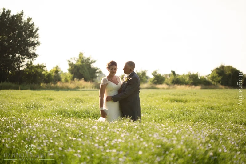 bride and groom in flower field at houchins wedding