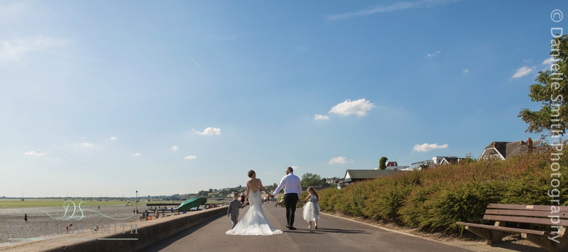 bride and groom and kids at the beach on wedding day