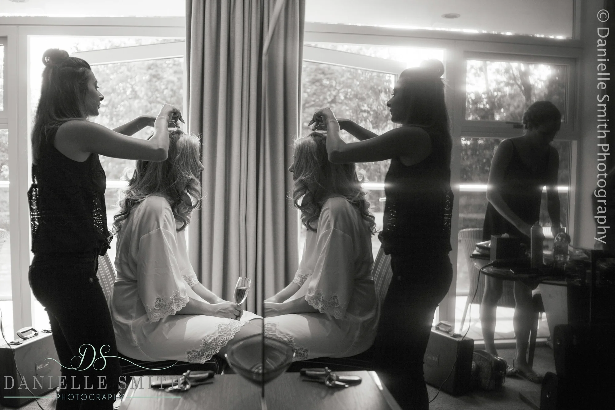 bride having hair done in mirror