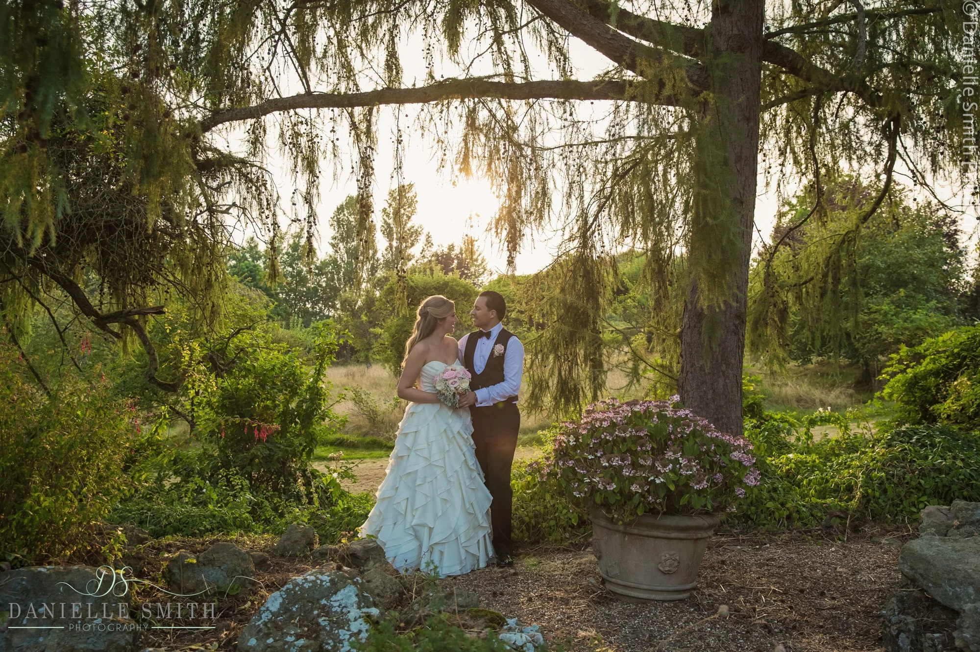 bride and groom in gardens as sun goes down