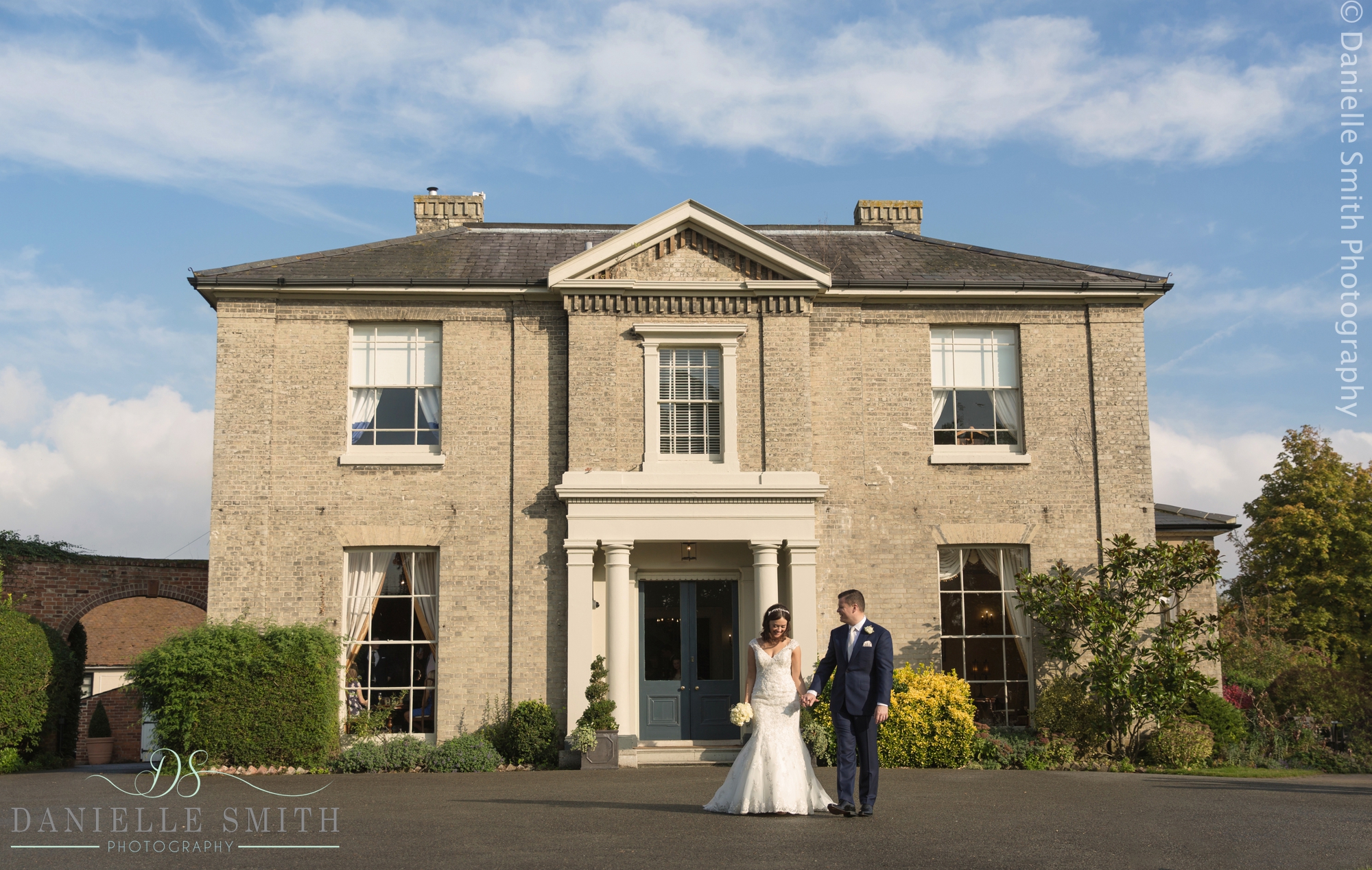 bride and groom walking in front of house at fennes