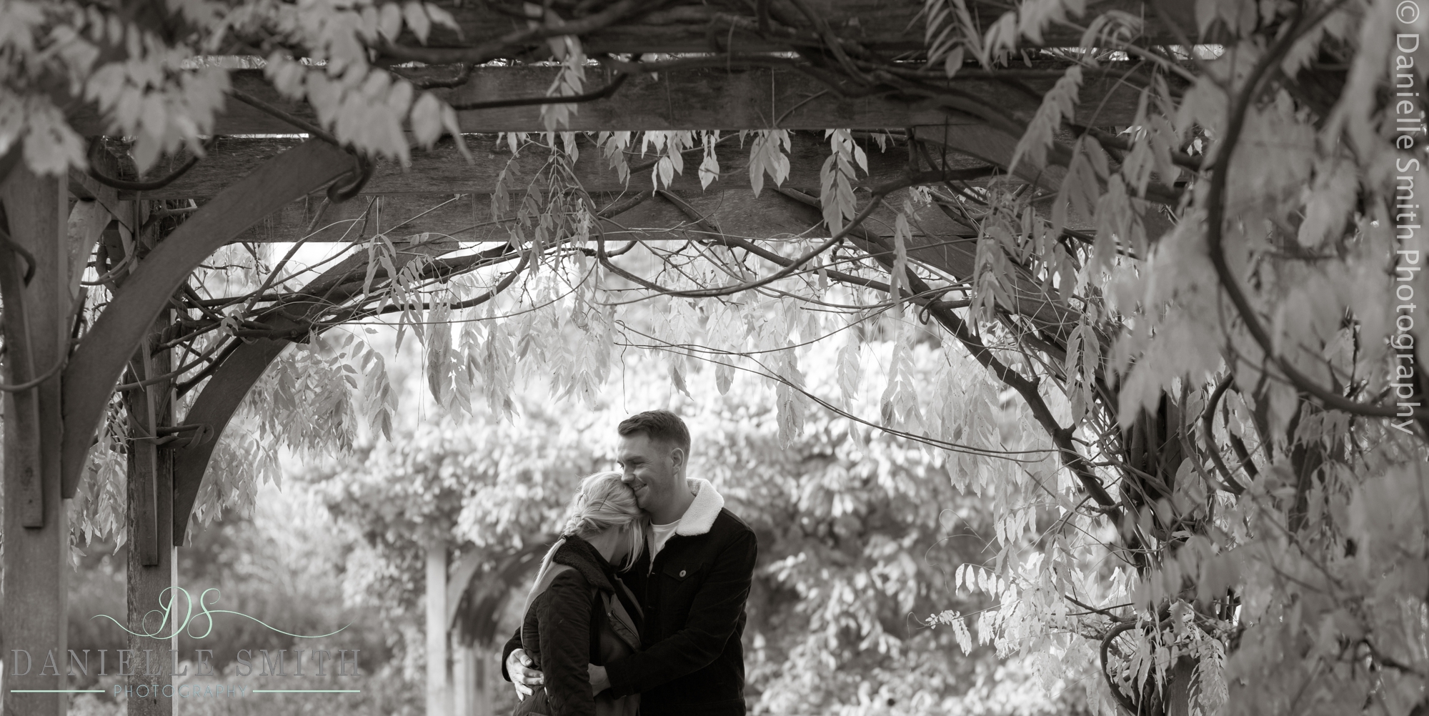 couple hugging under pergola in highlands park