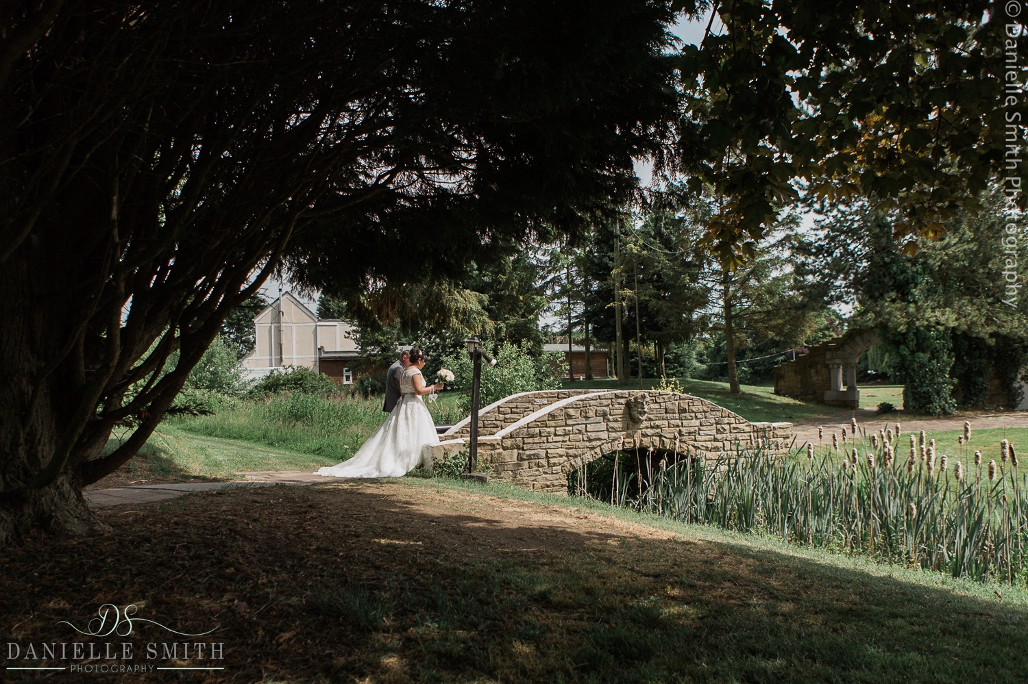 bride and groom walking over bridge