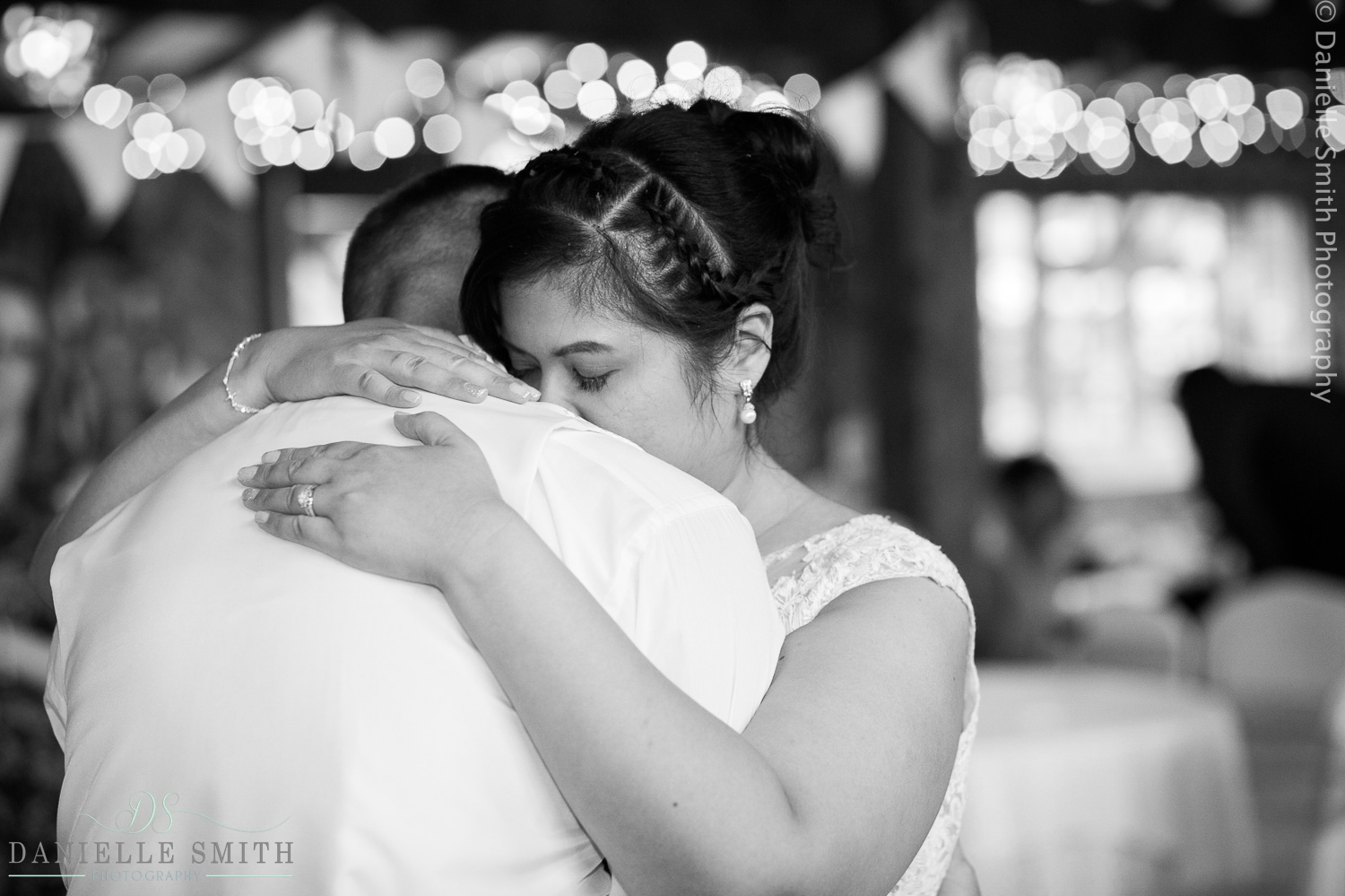 bride and groom hugging during first dance at barn wedding