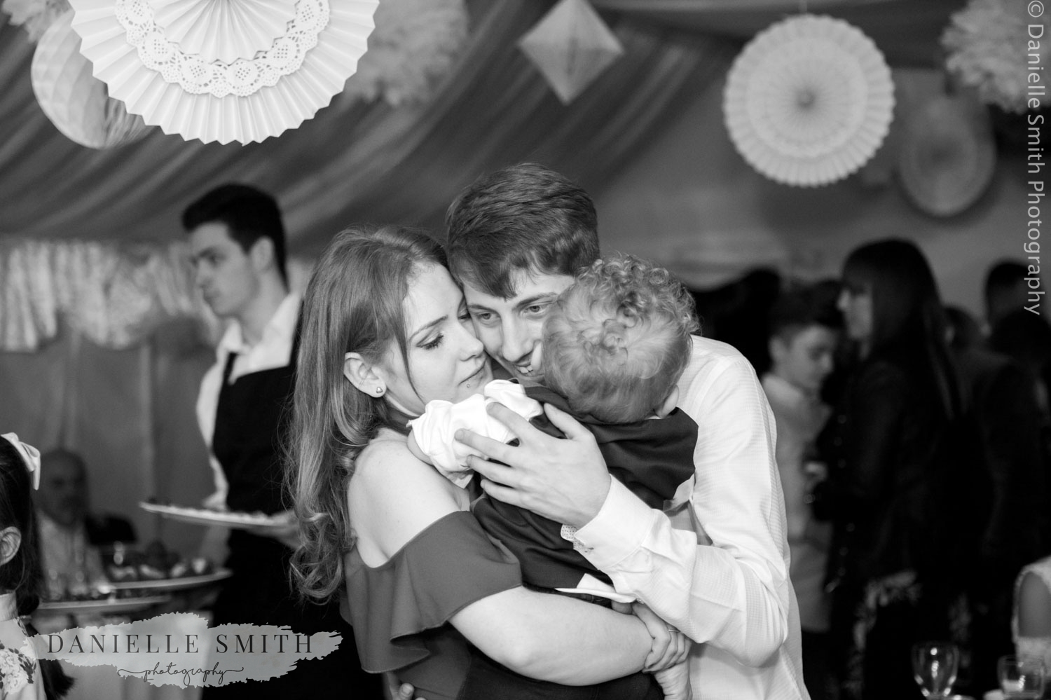 family of three hugging at wedding