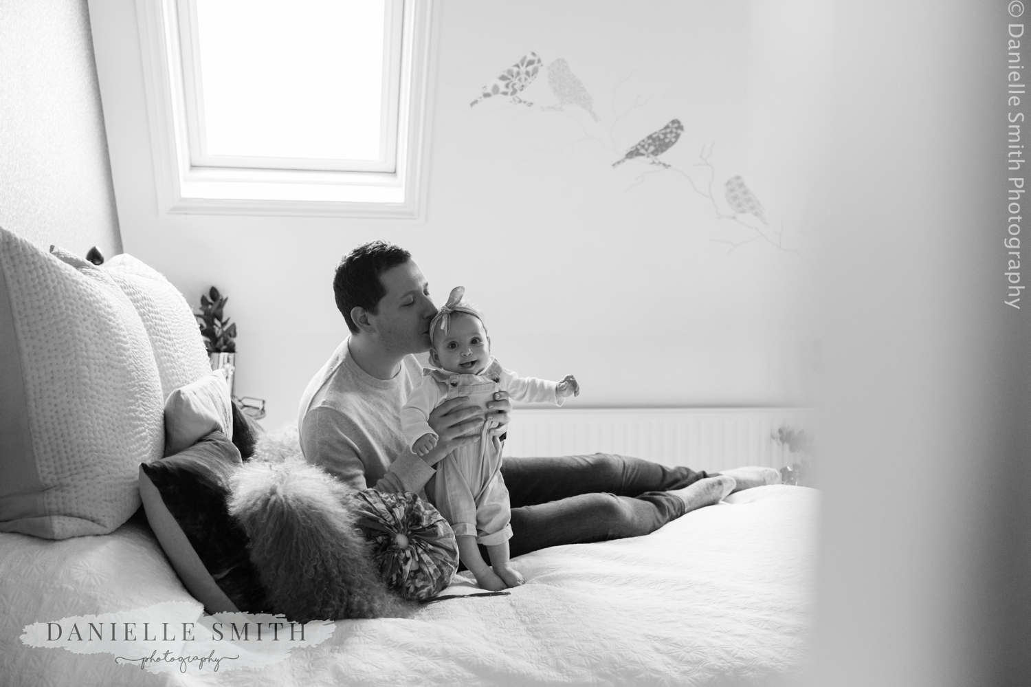 dad kissing daughters head at home