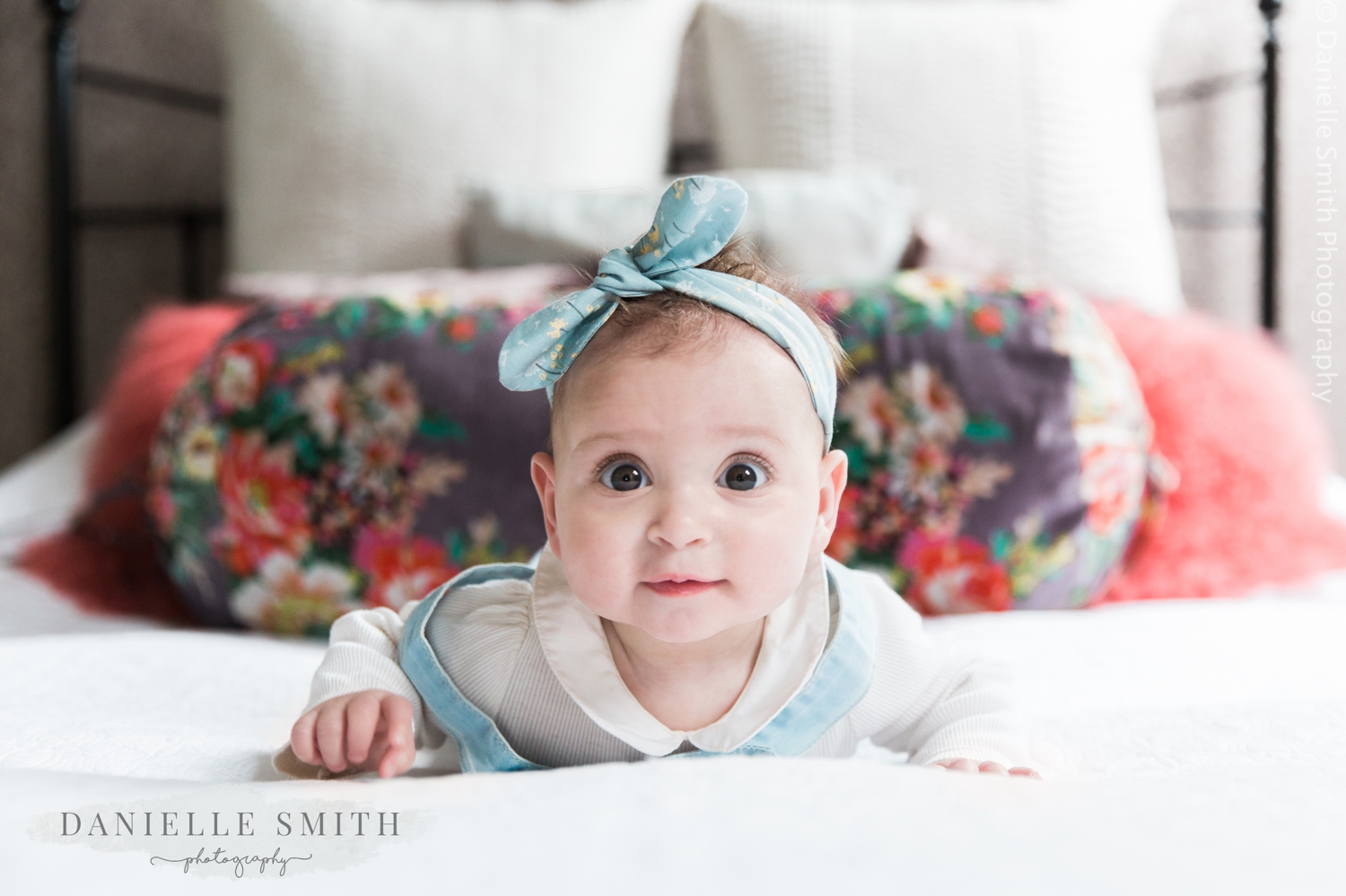 baby girl laying on front on bed - natural family photos