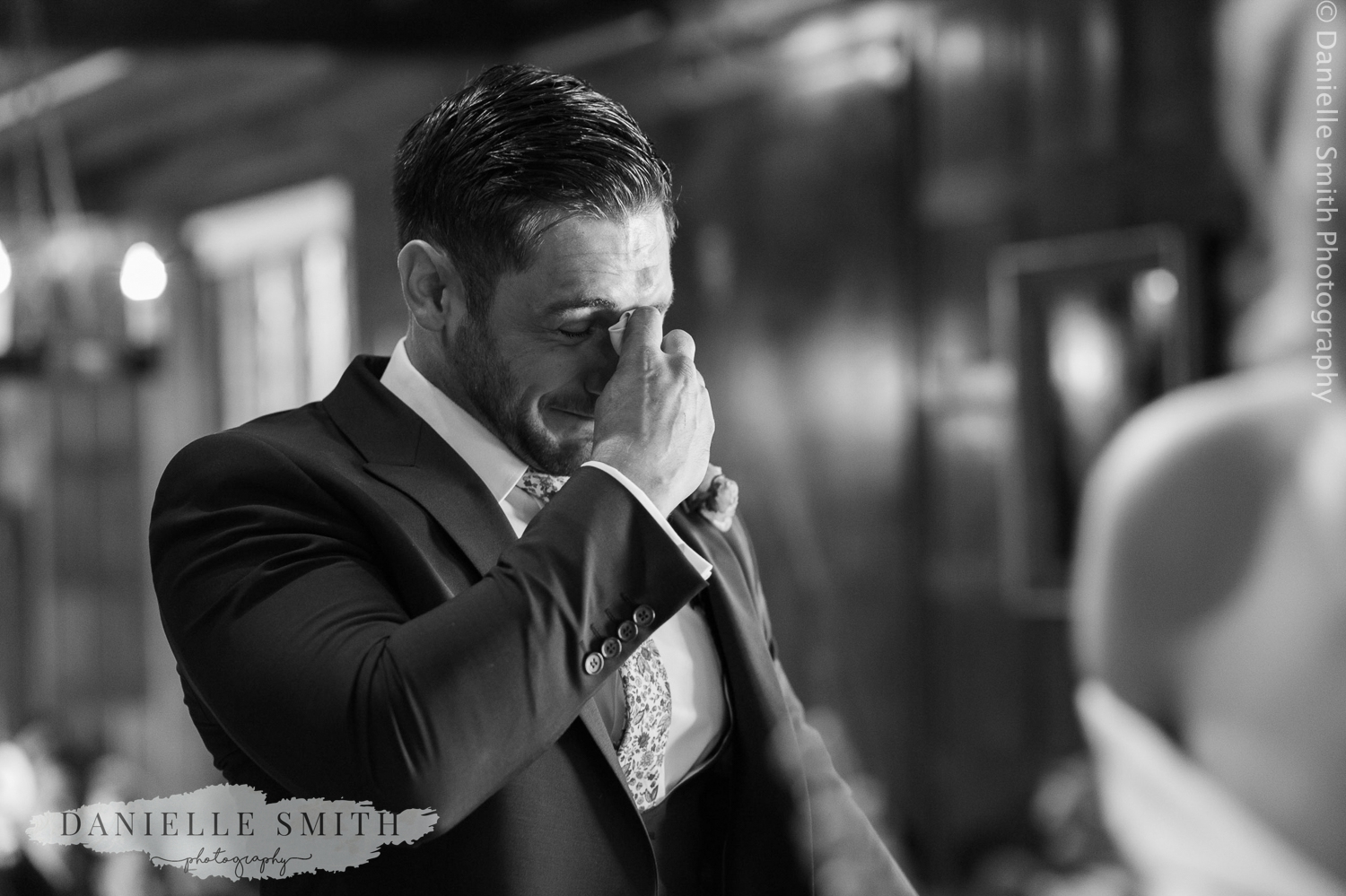 groom in tears while bride walks down the aisle