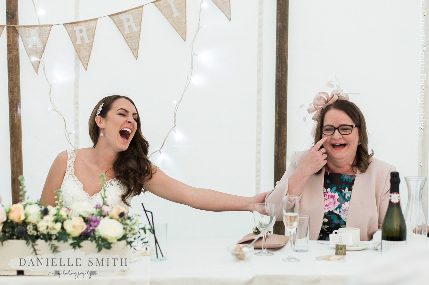 bride and her mum laughing during the wedding speeches