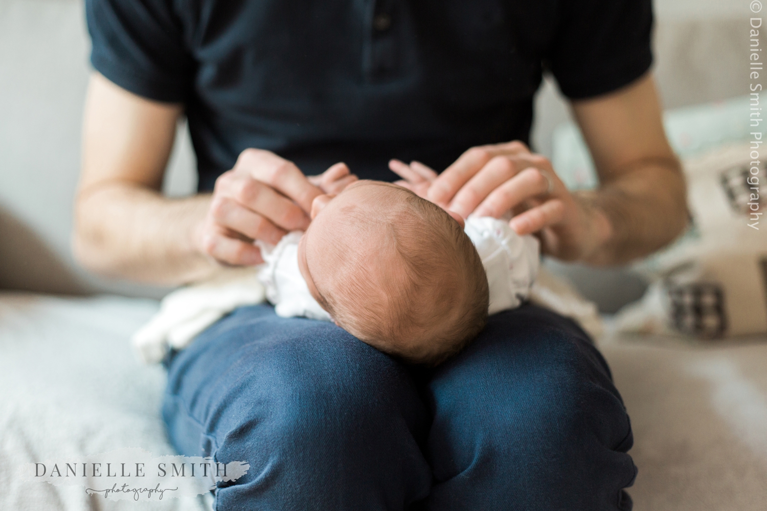 newborn baby on dads lap