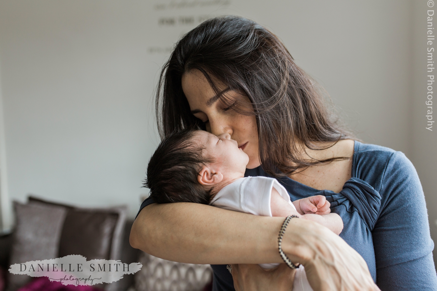 new mum kissing baby's head