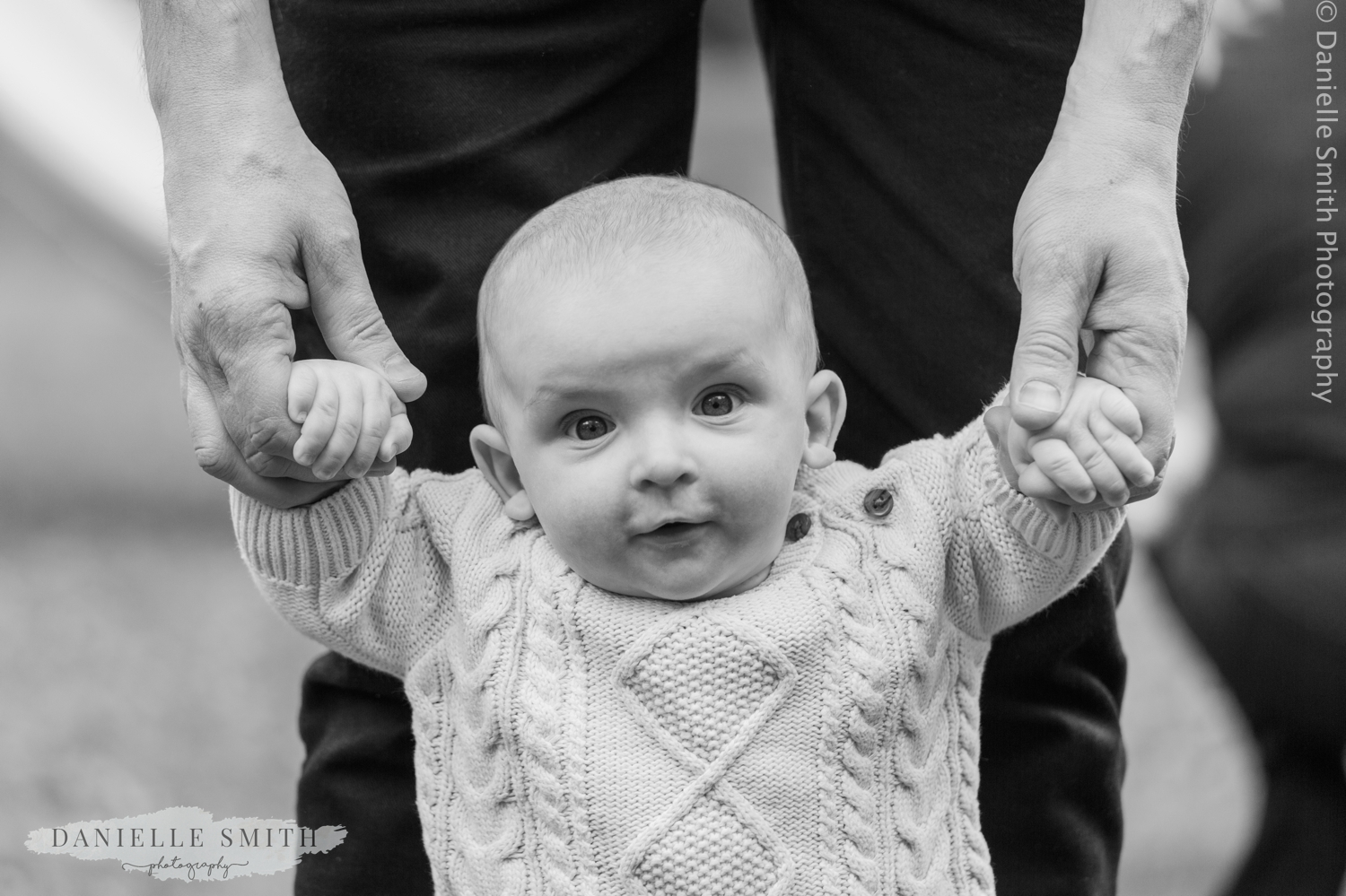 dad holding baby boy's hands