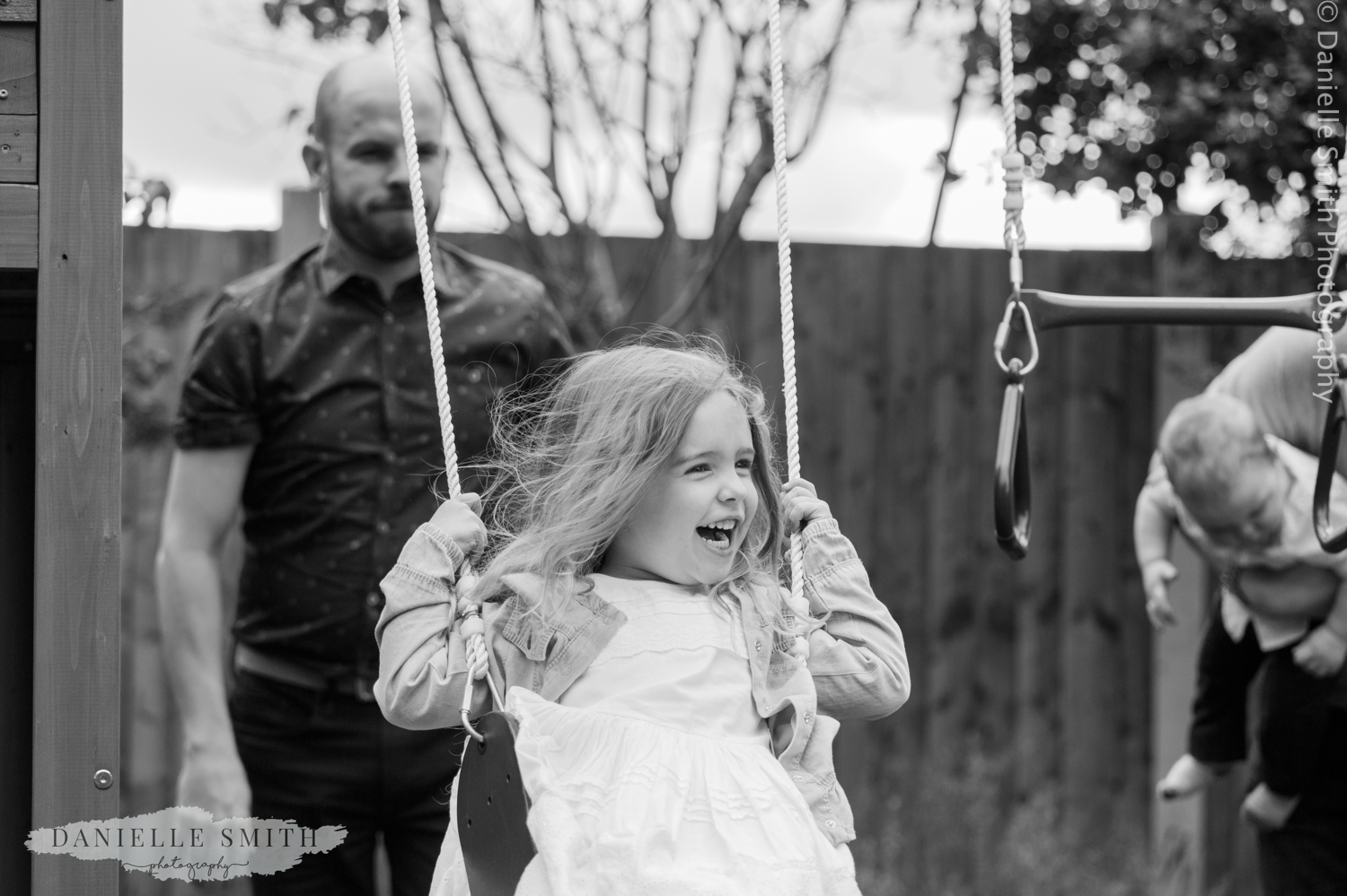 uncle pushing girl on swing