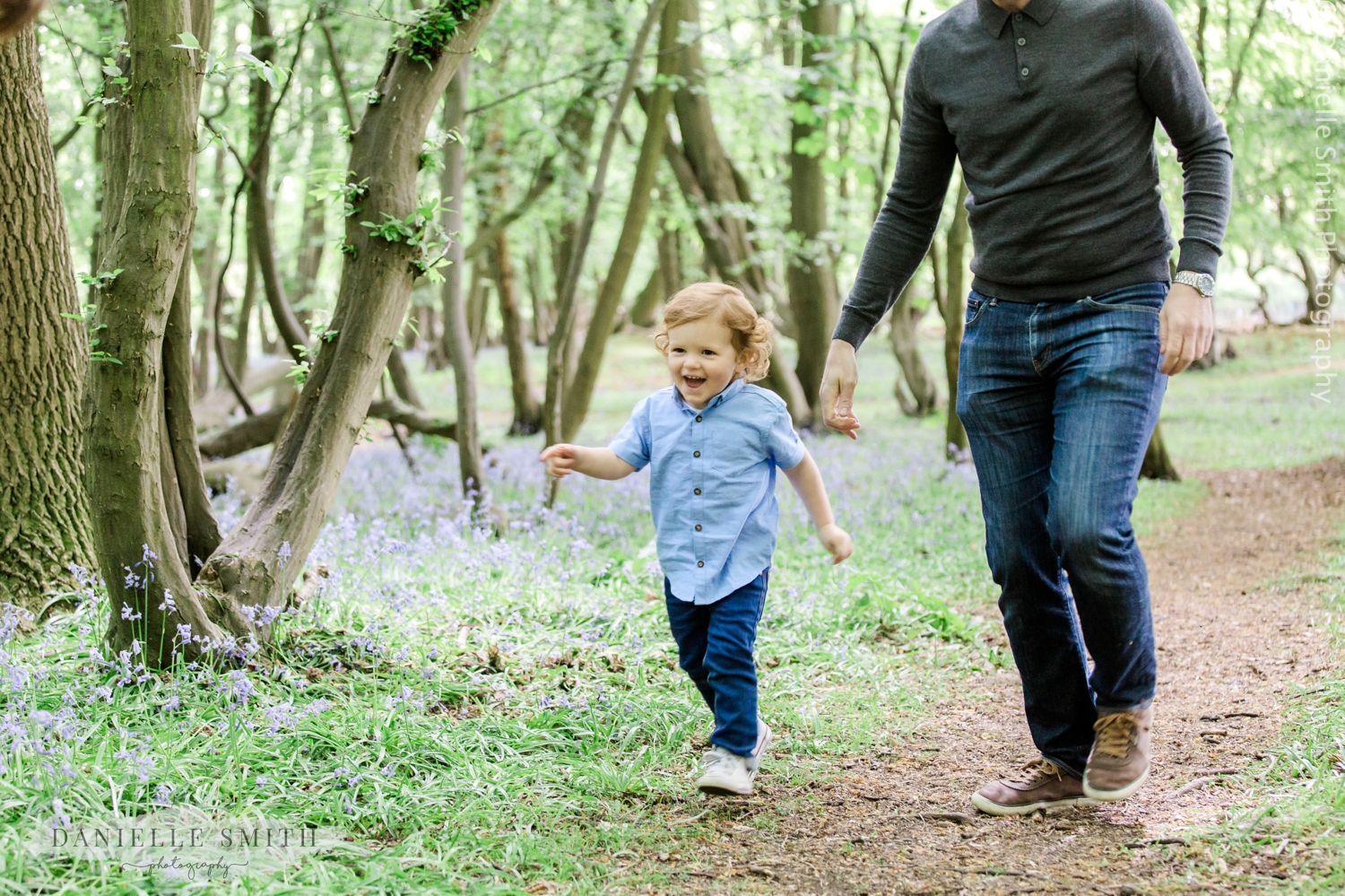 boy running with dad in bluebell woods