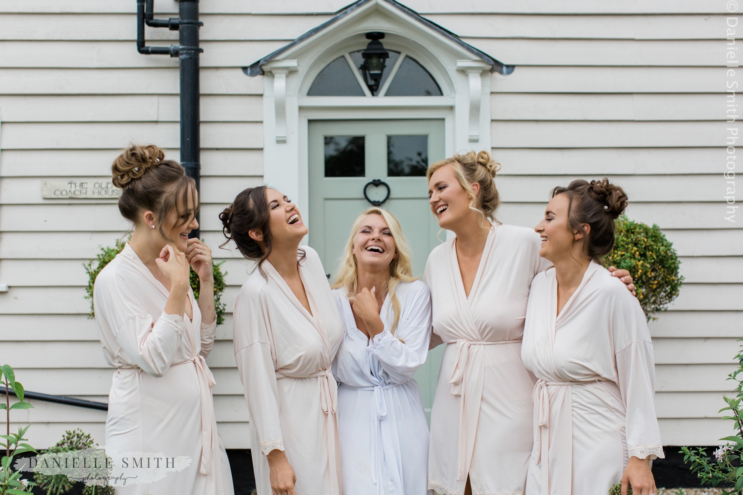 bride and bridesmaids laughing outside blake hall