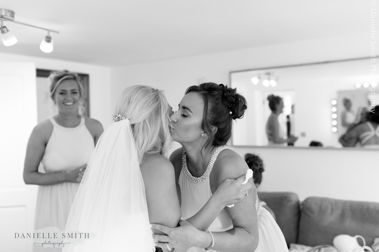bridesmaid kissing bride