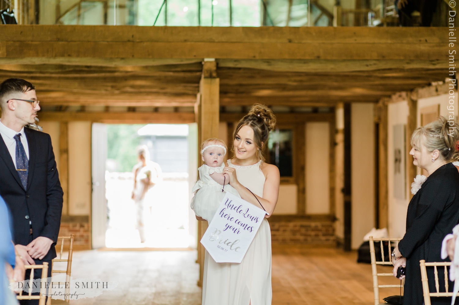 bridesmaid and baby flower girl walking down aisle