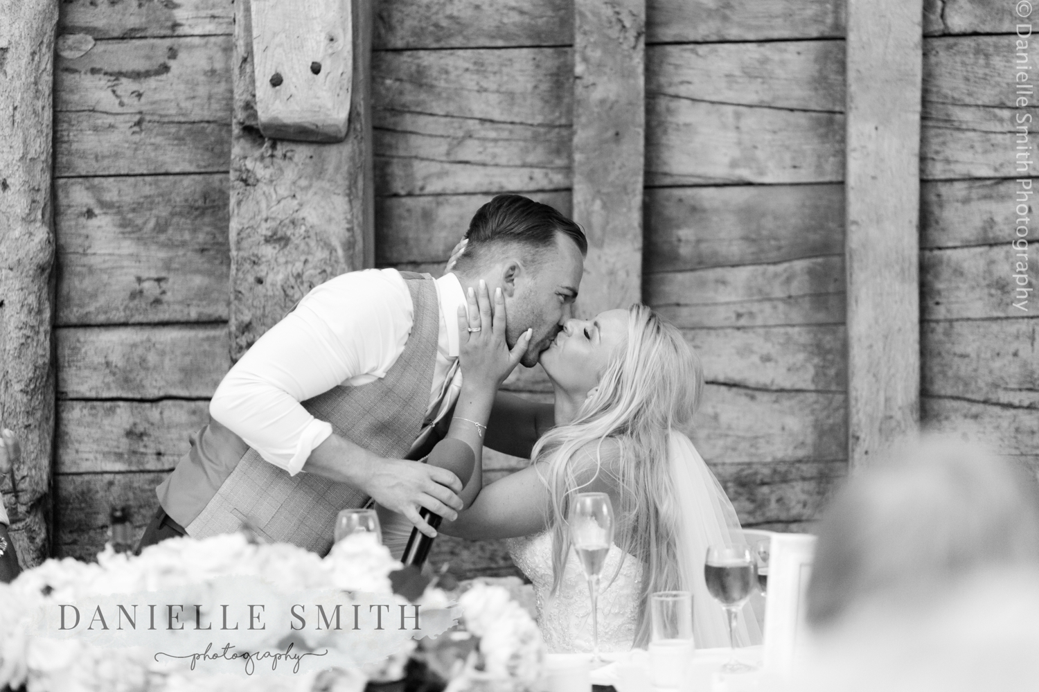 bride and groom kissing during speeches