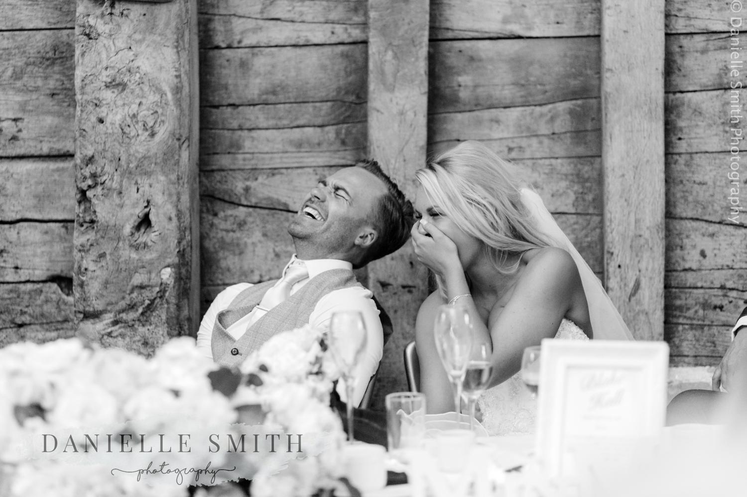 bride and groom laughing during the speeches at the wedding bride and groom laughing - blake hall wedding photography