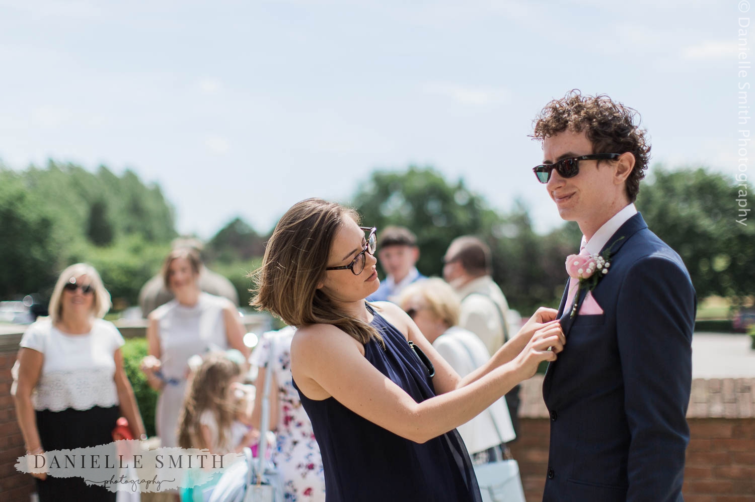 lady fixing best man button hole