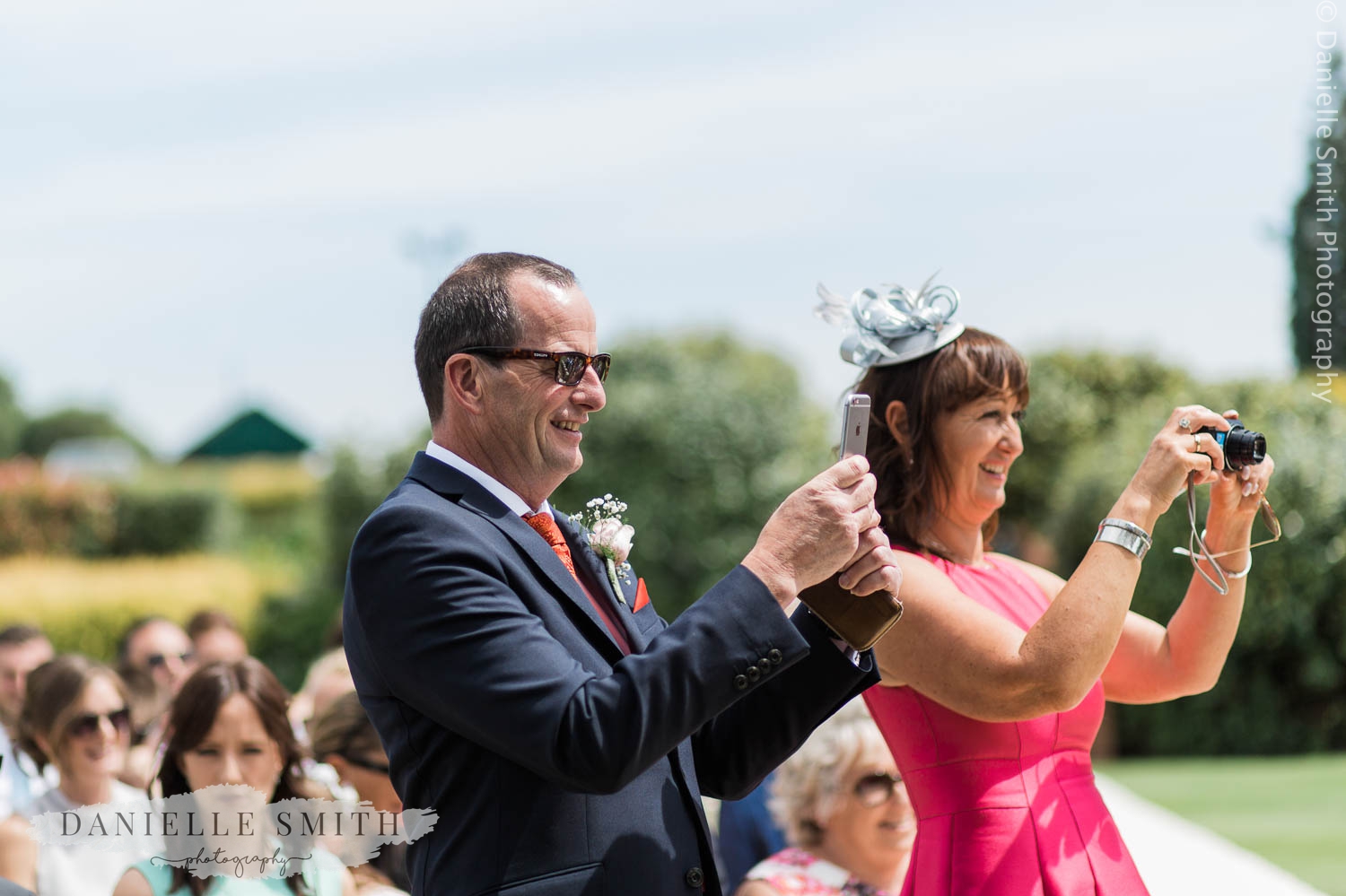 wedding guests taking photos at outdoor ceremony