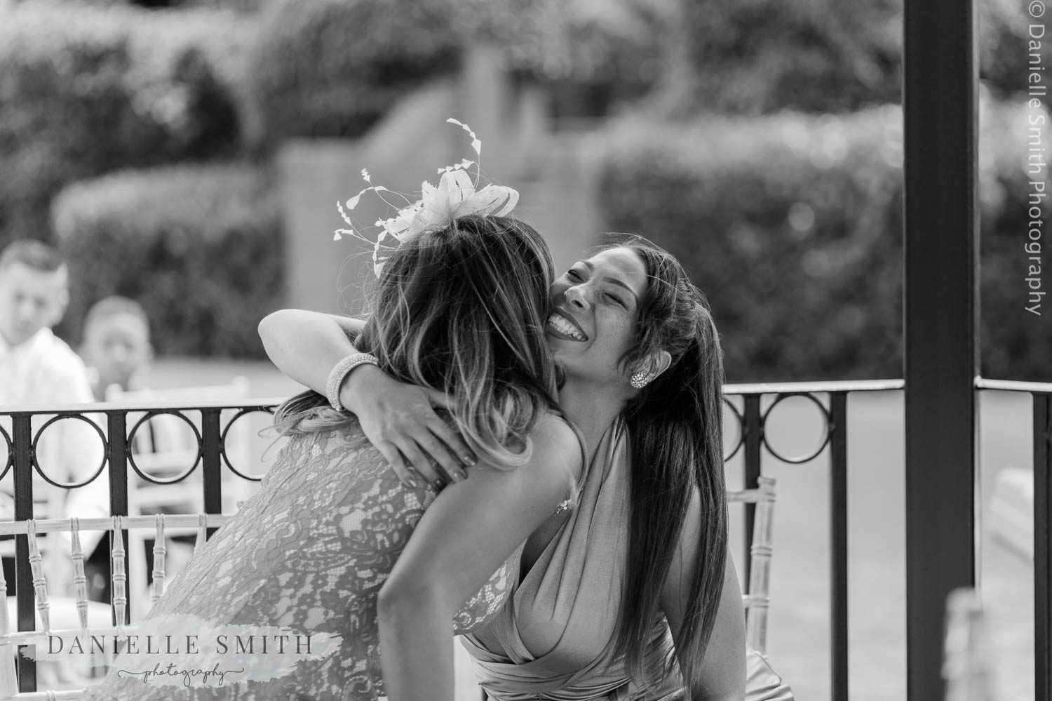 ladies hugging at outdoor wedding ceremony