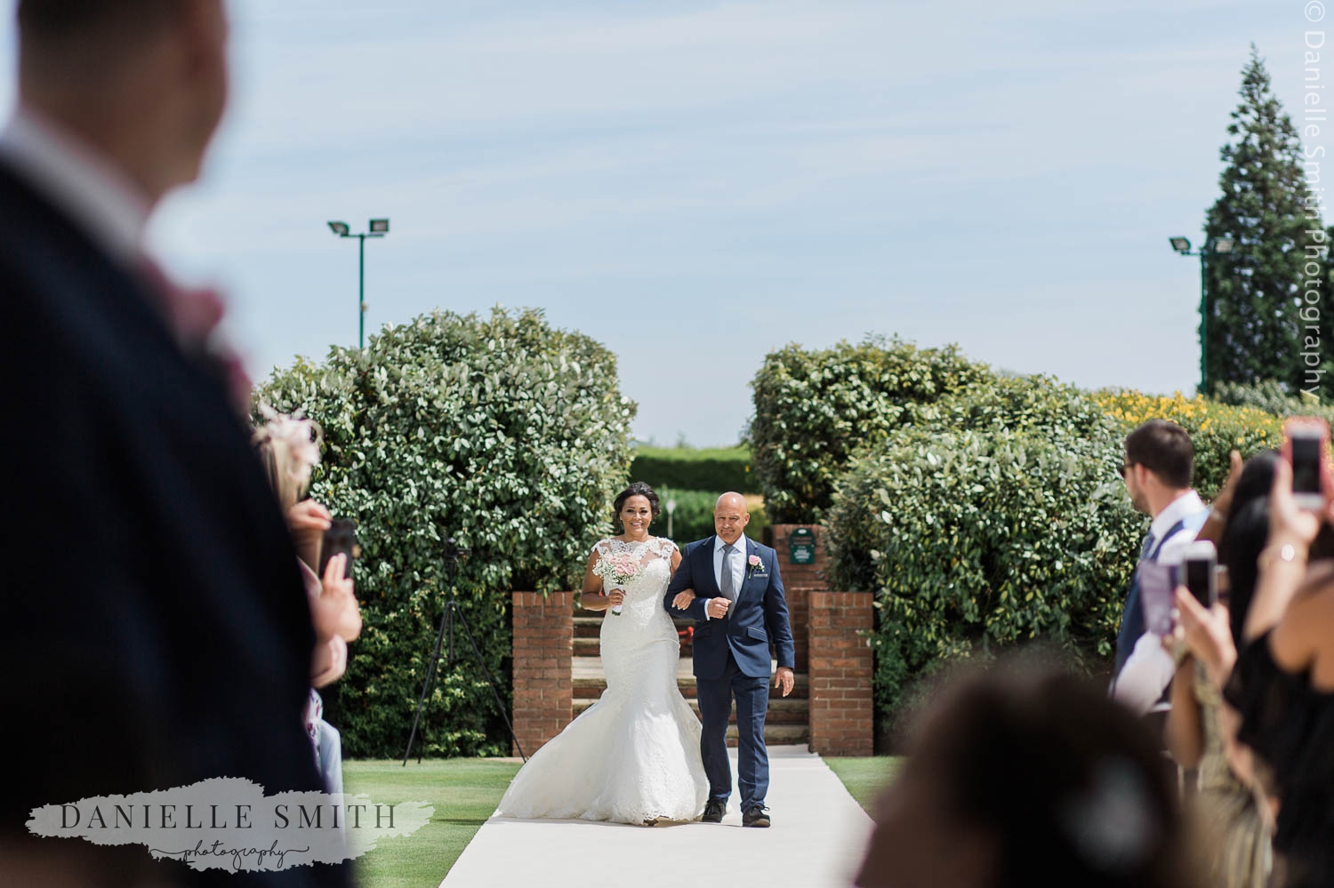 father walking daughter down aisle outside