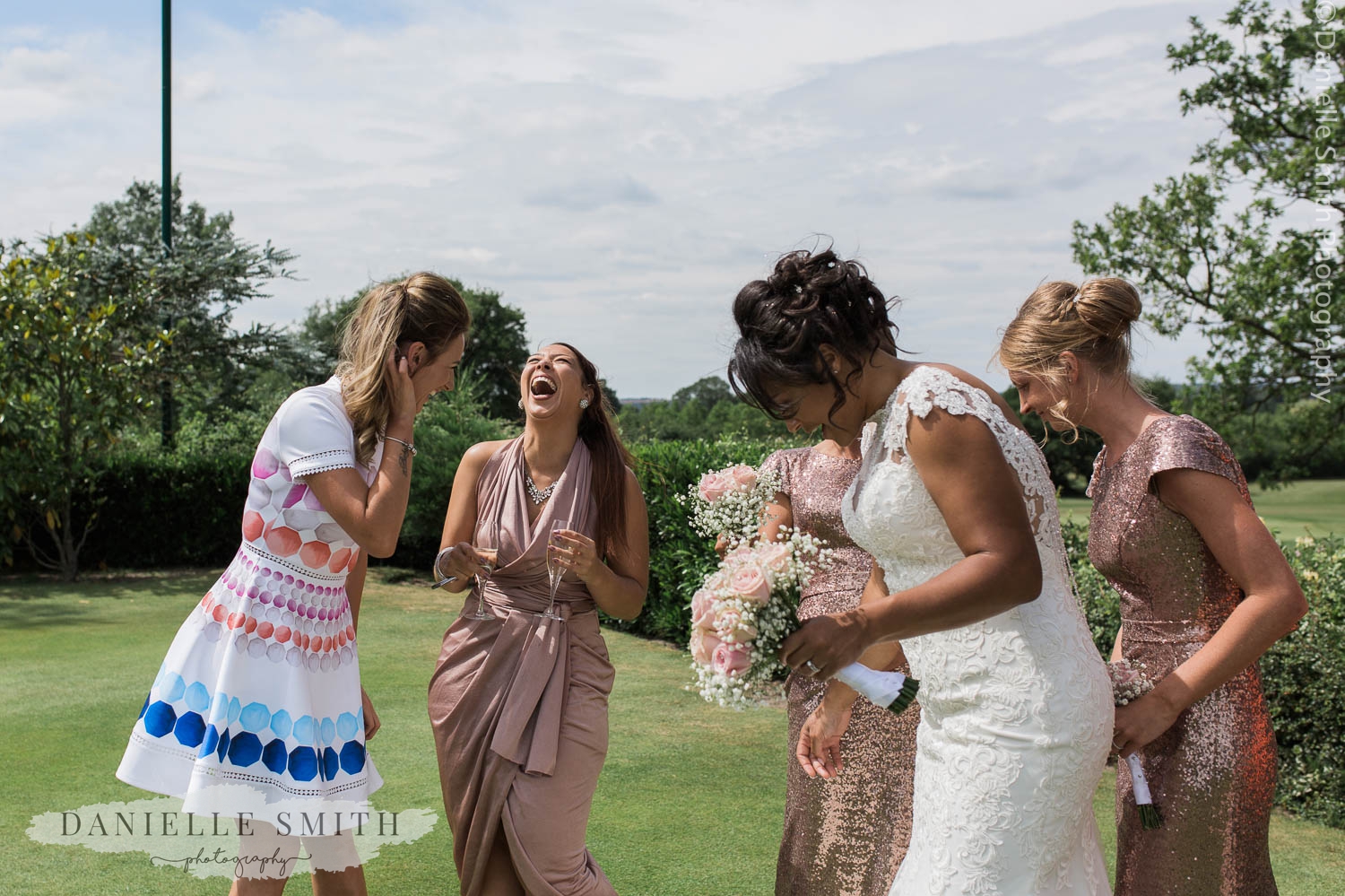 bride and bridesmaids laughing in gardens