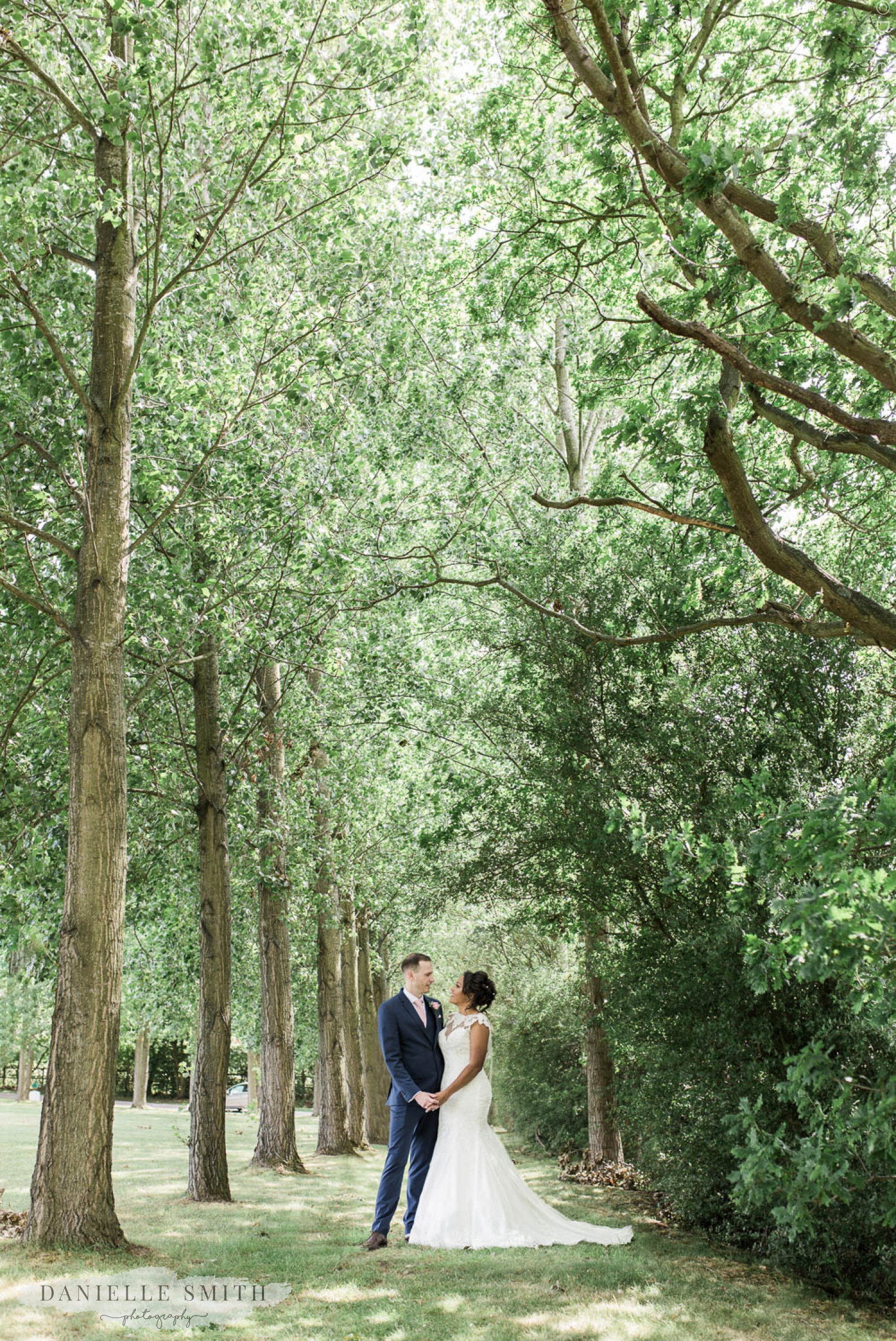 bride and groom between trees