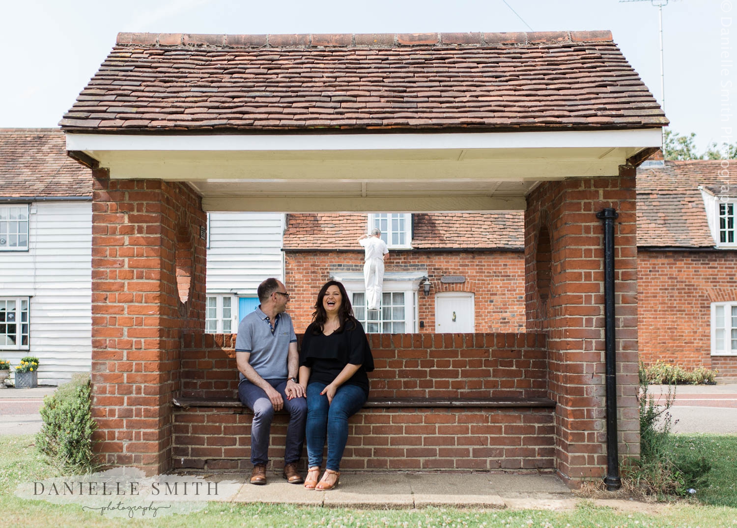 couple sitting at brick bus stop - stock village engagement session