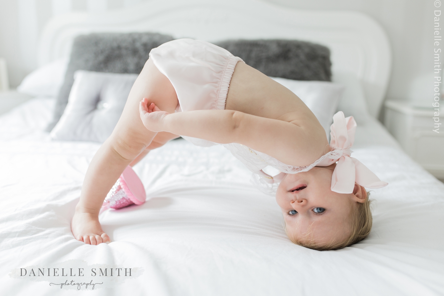 little girl doing head stand - first birthday photo shoot