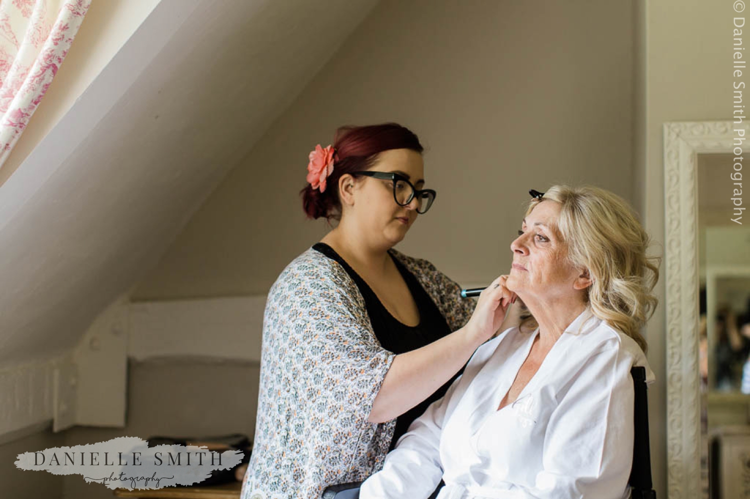 bride having her make up done at Houchins