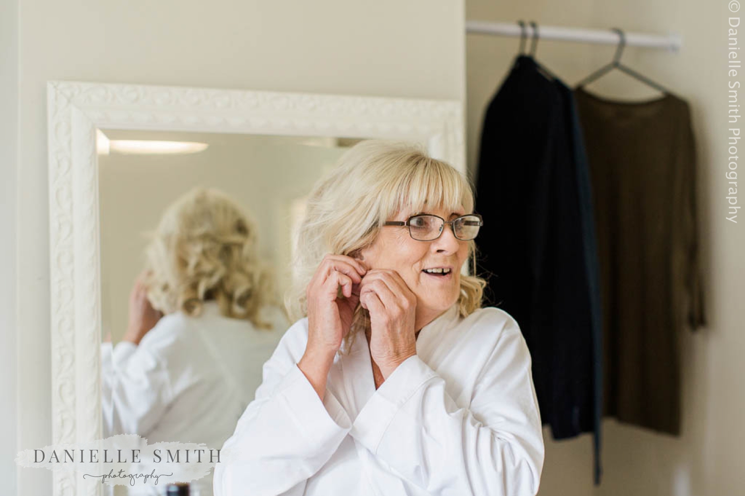 bride putting her earrings in