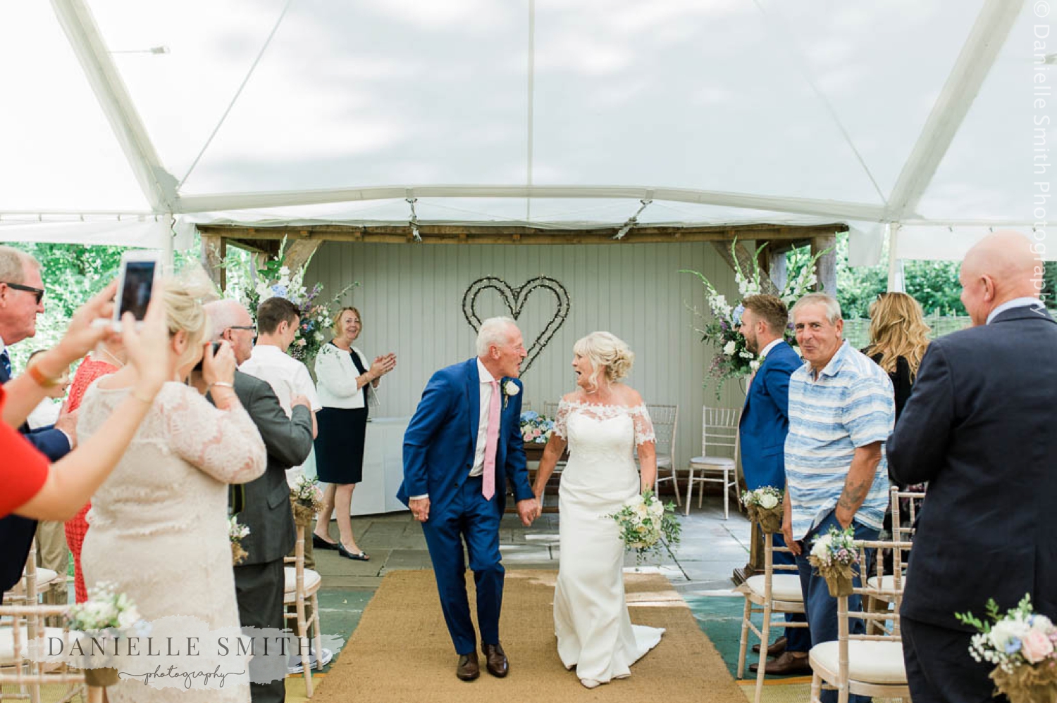 bride and groom singing and dancing down aisle