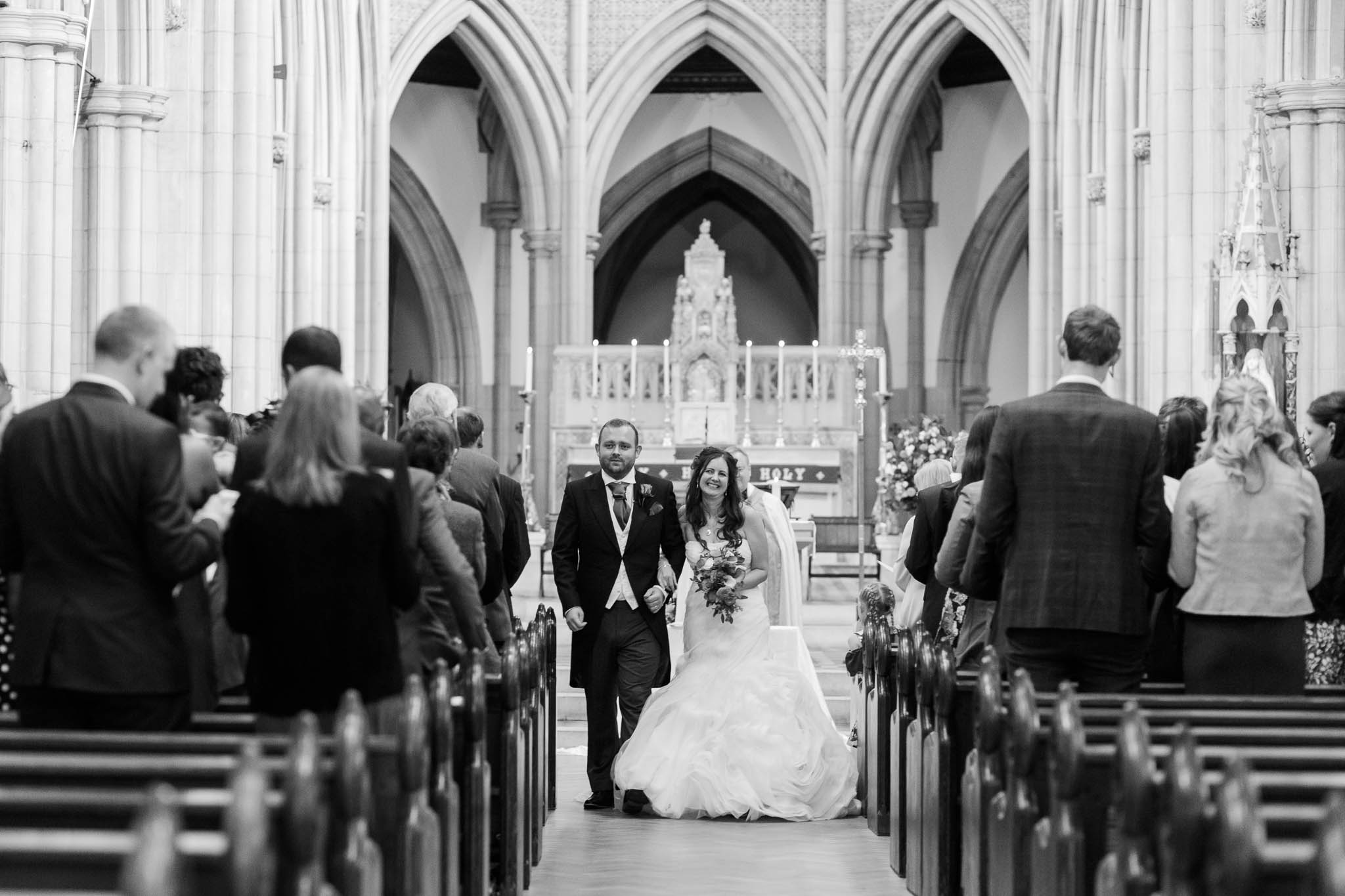bride and groom walking down aisle just married