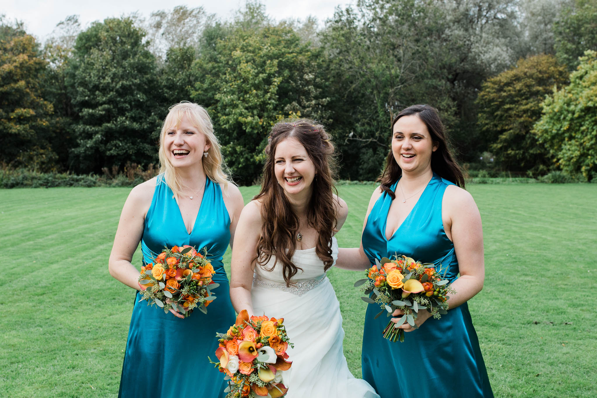 bride laughing with bridesmaids at autumn wedding